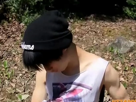 A small and pretty Asian boy pleasuring himself with anal beads outdoors.