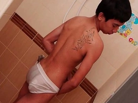 Asian twink gets a handjob while pissing in the shower